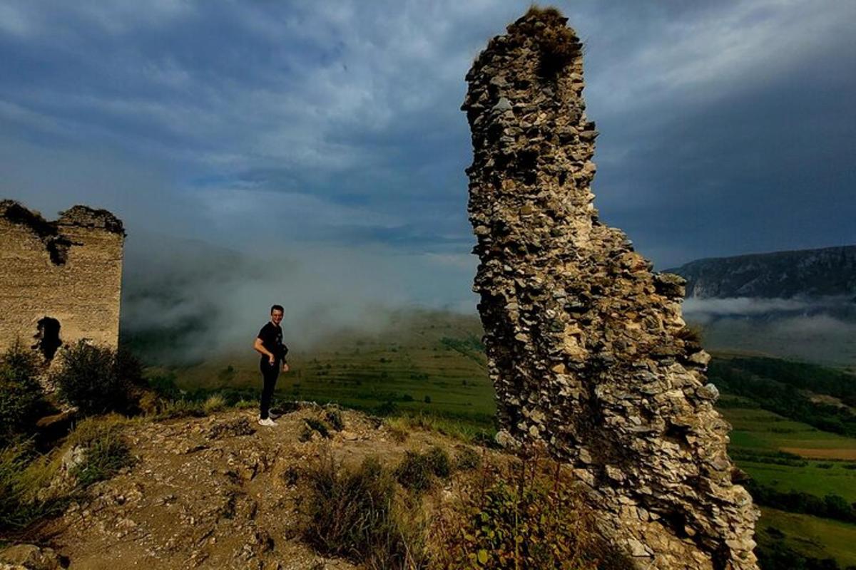 muž stojící na vrcholu kopce