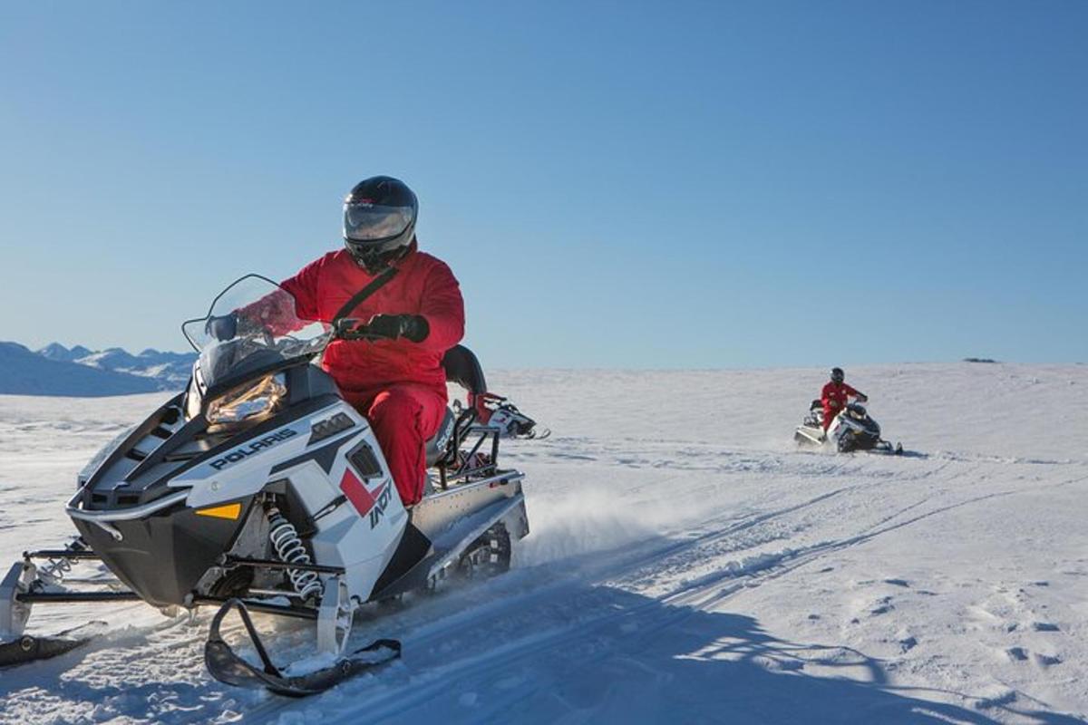 un bărbat merge cu un snowmobil în zăpadă