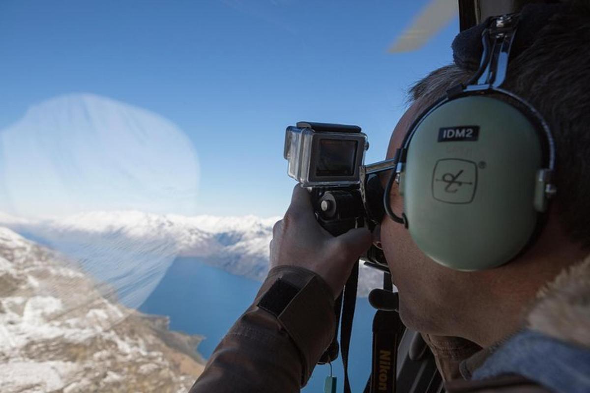 en mann som tar et bilde av et fjell med et kamera