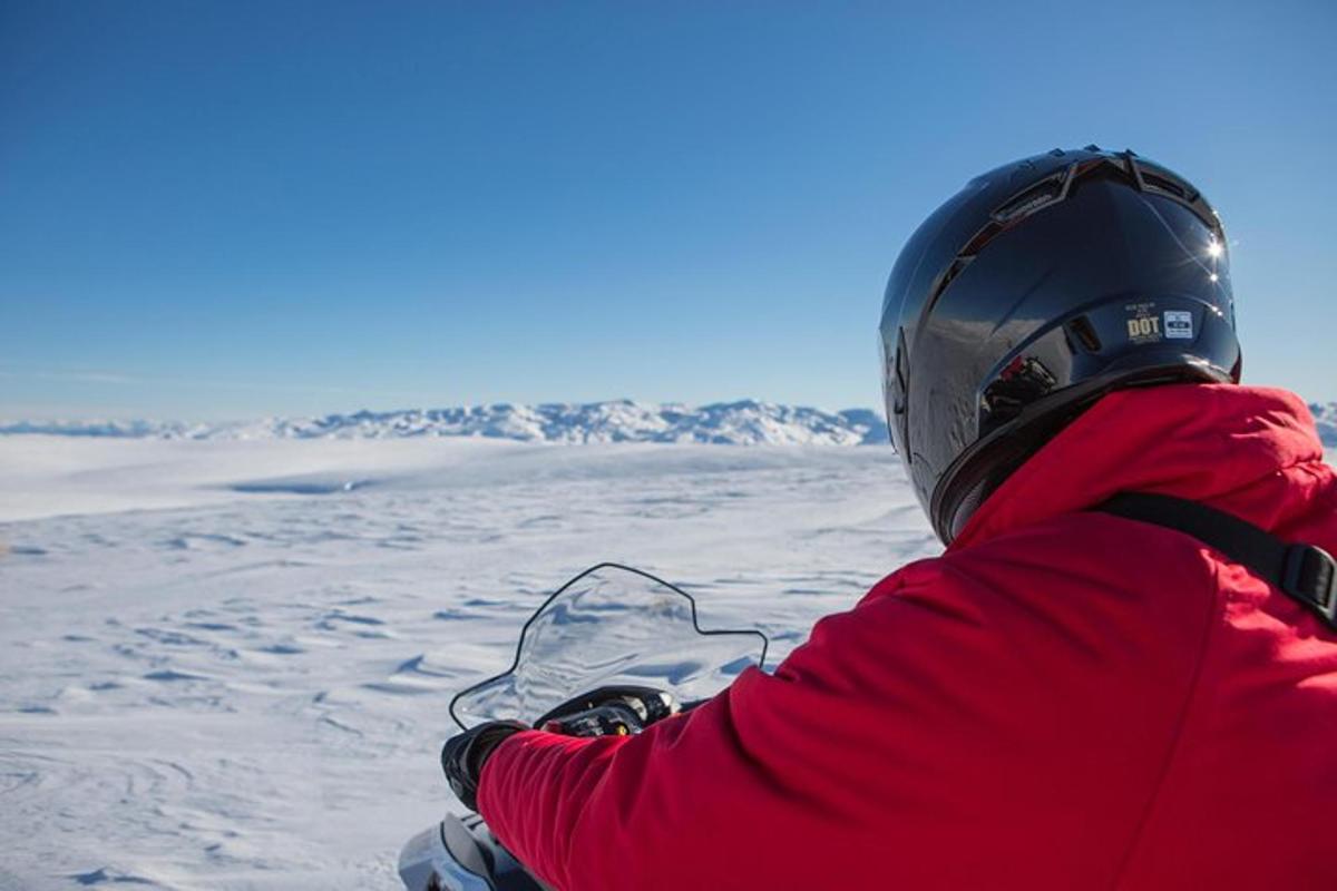 osoba sedící na snowboardu ve sněhu