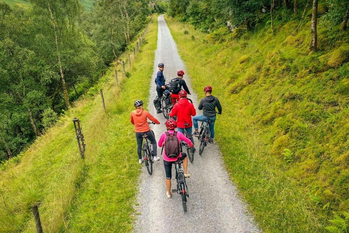 a group of people riding bikes down a dirt road