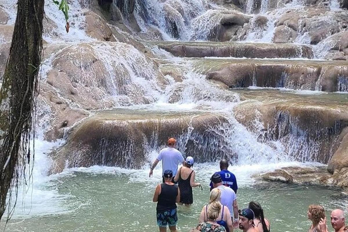 滝の近くの水の中に立っている人々のグループ