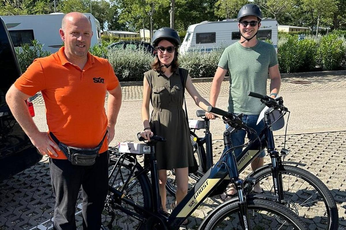 dvaja muži a žena stojaci vedľa bicykla