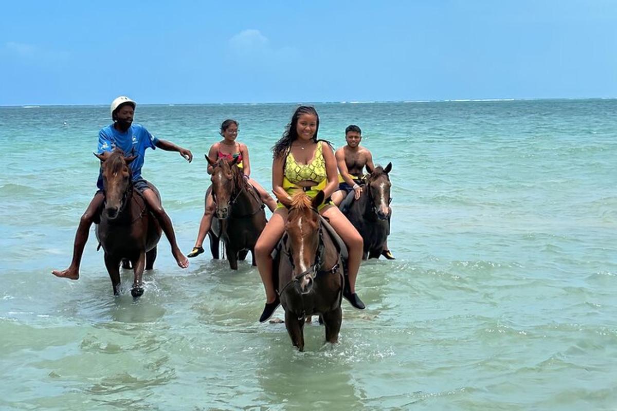 un grup de persones muntant a cavall a l'oceà