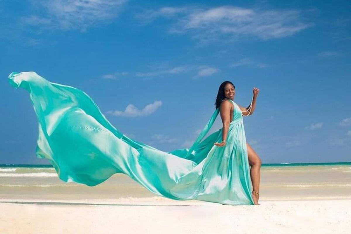 a woman in a blue dress standing on a beach