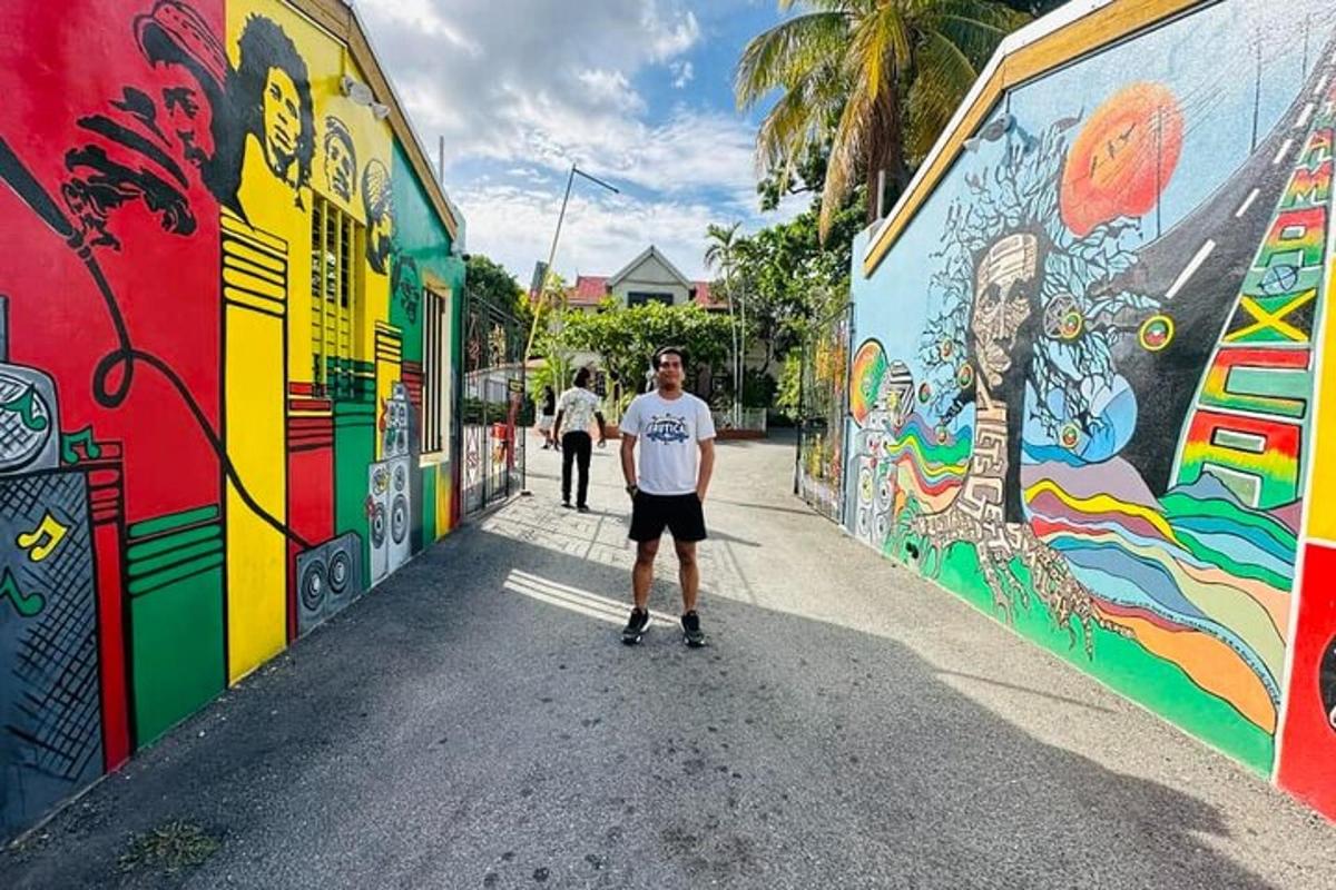 egy férfi áll egy graffitivel borított fal előtt