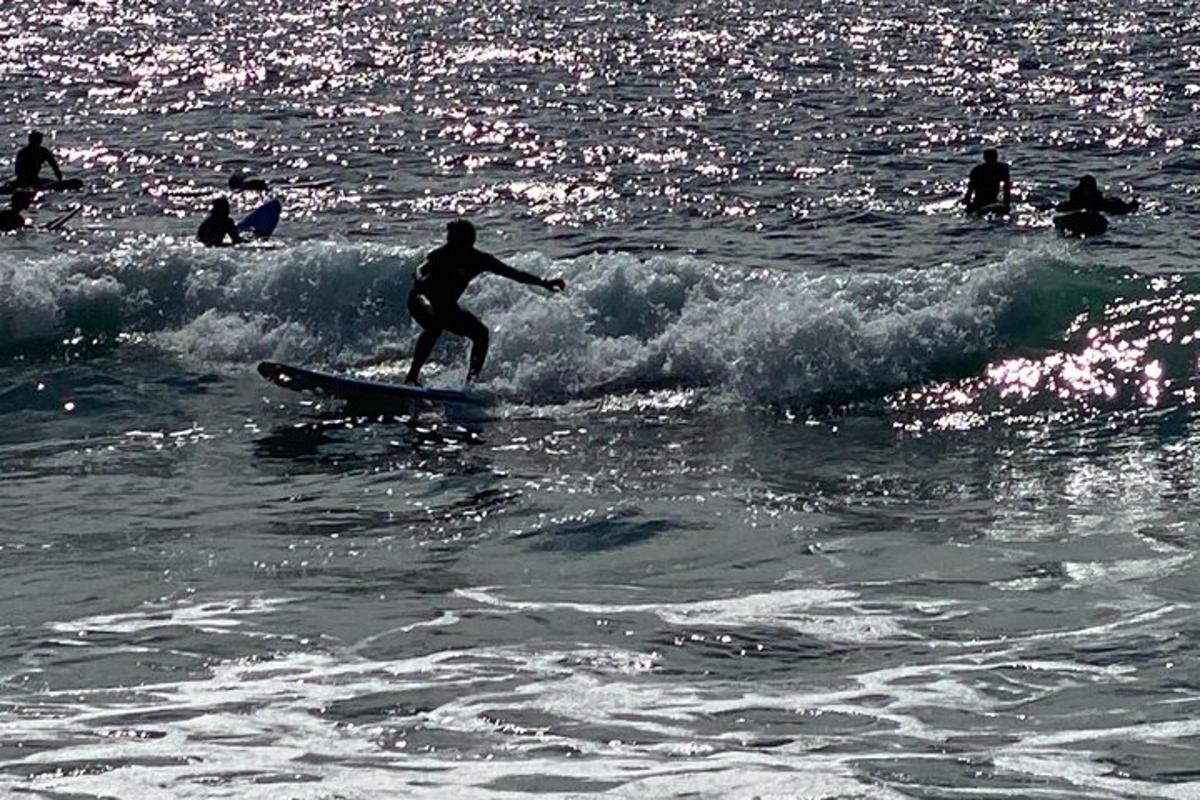 en mand, der rider på en bølge på et surfbræt i havet