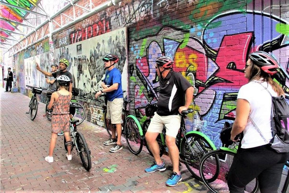 skupina lidí stojící vedle zdi s graffiti
