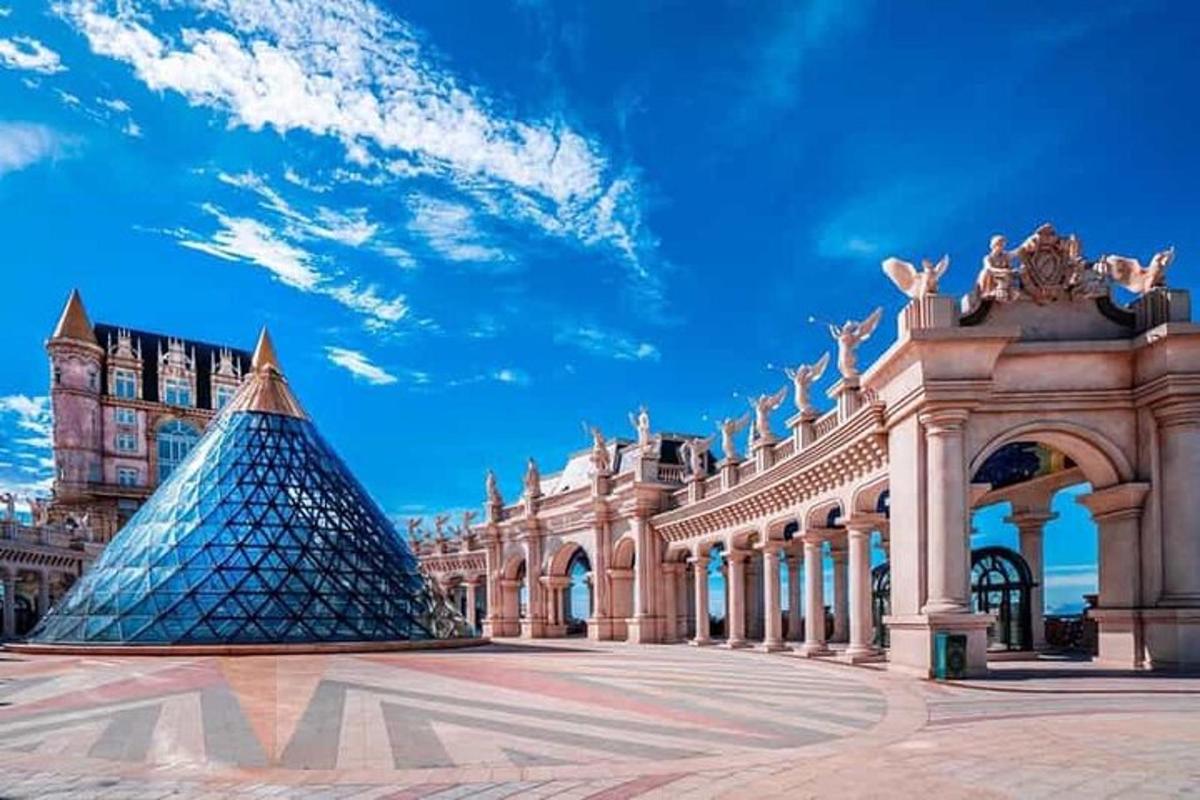 một kim tự tháp bằng kính ở phía trước một tòa nhà