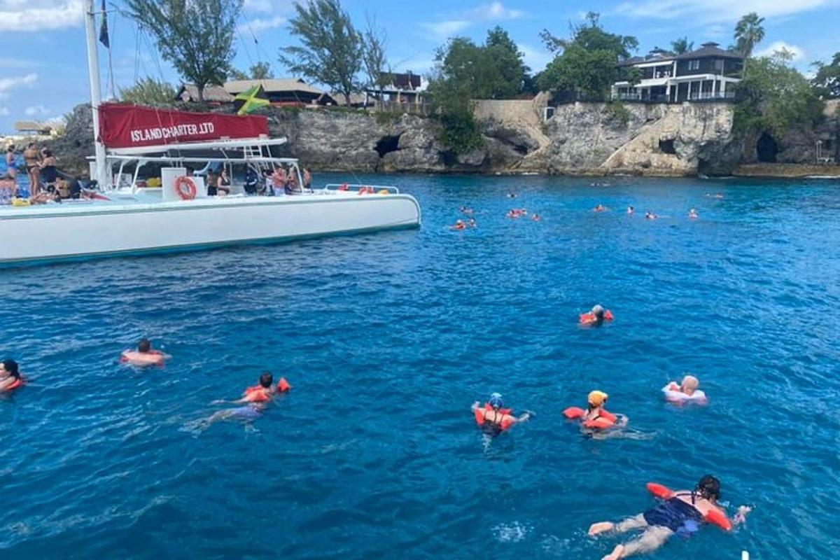 un grup de persones nedant a l'aigua al costat d'una barca