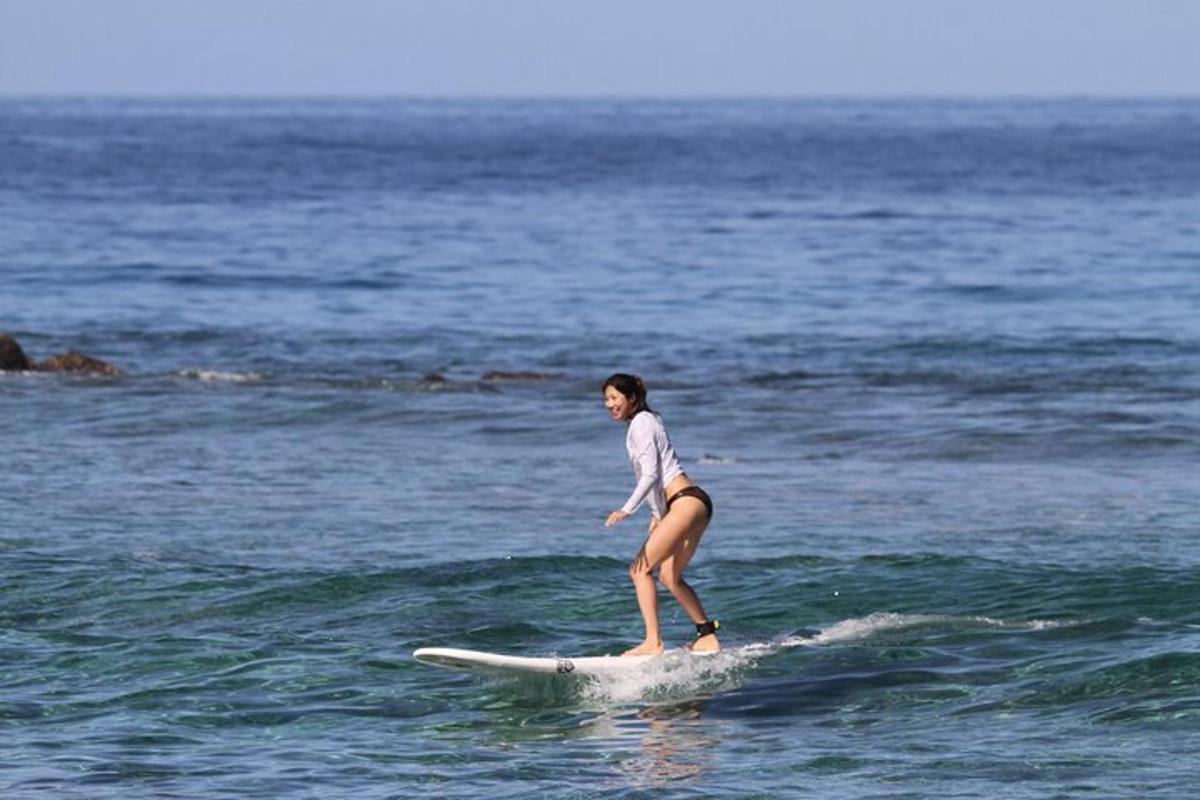 a woman in a bikini riding a surfboard in the ocean