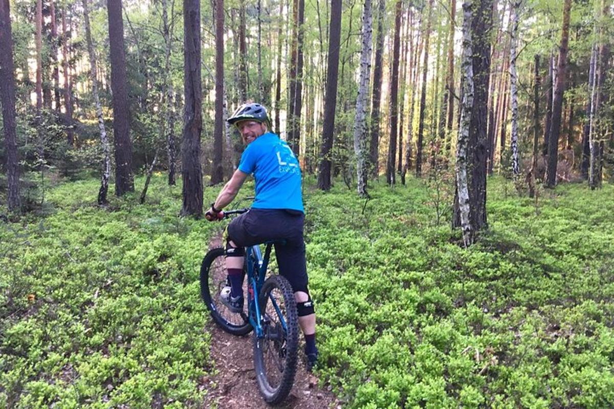 森の中の小道で自転車に乗る男性