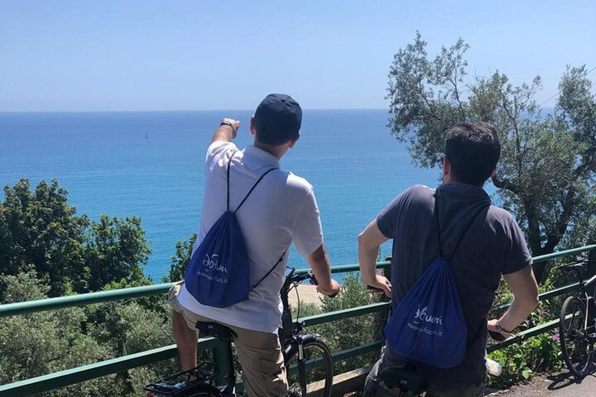 two men on bikes looking out at the ocean