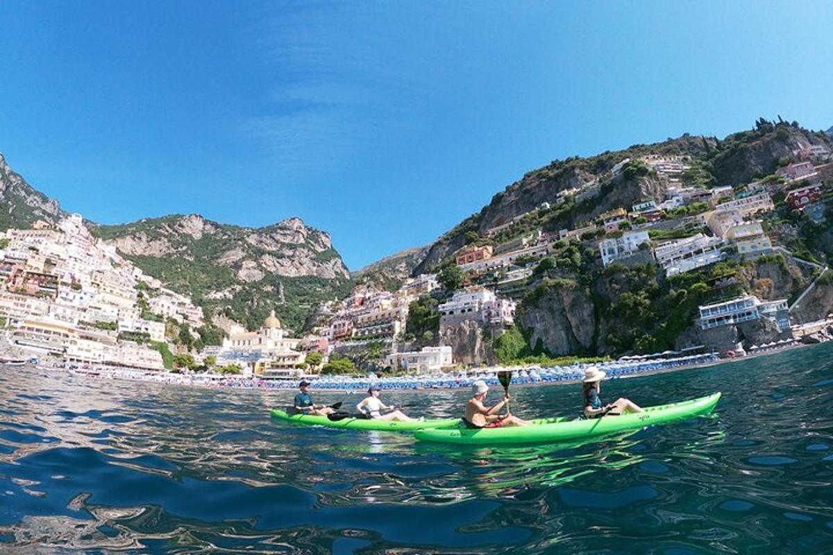 un grup de persones en una canoa verda a l'aigua