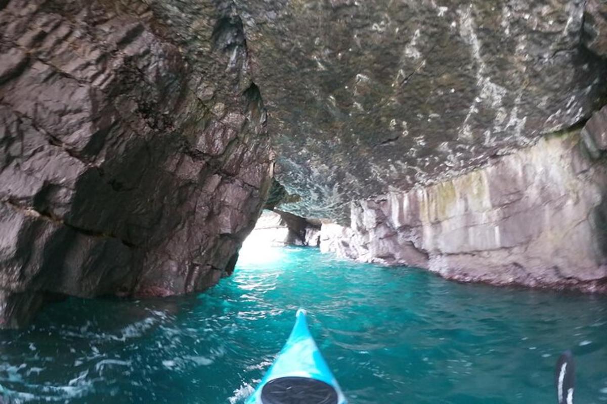 a blue kayak in a cave in the water