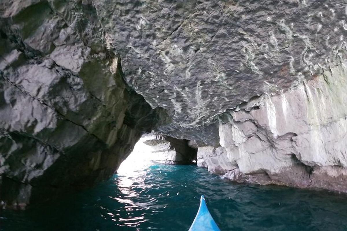 a blue kayak in a cave in the water
