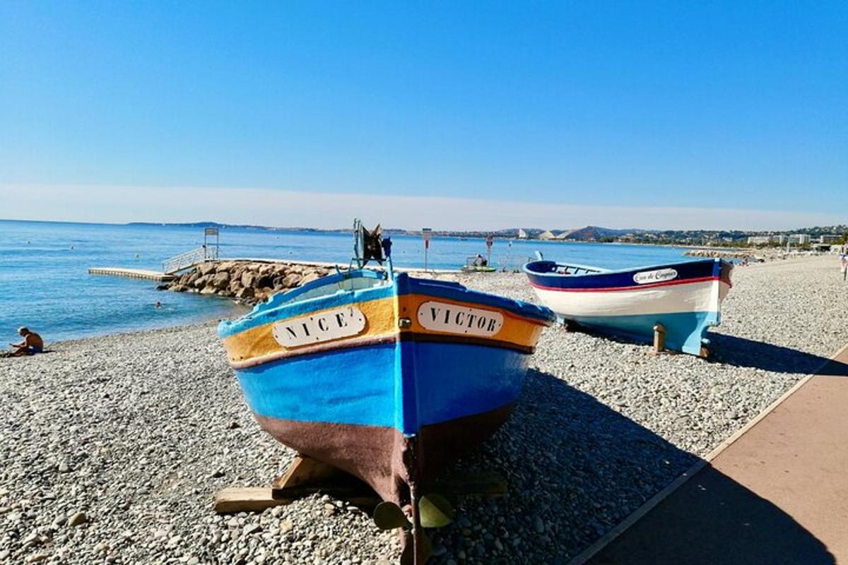 due barche sedute su una spiaggia vicino all'acqua