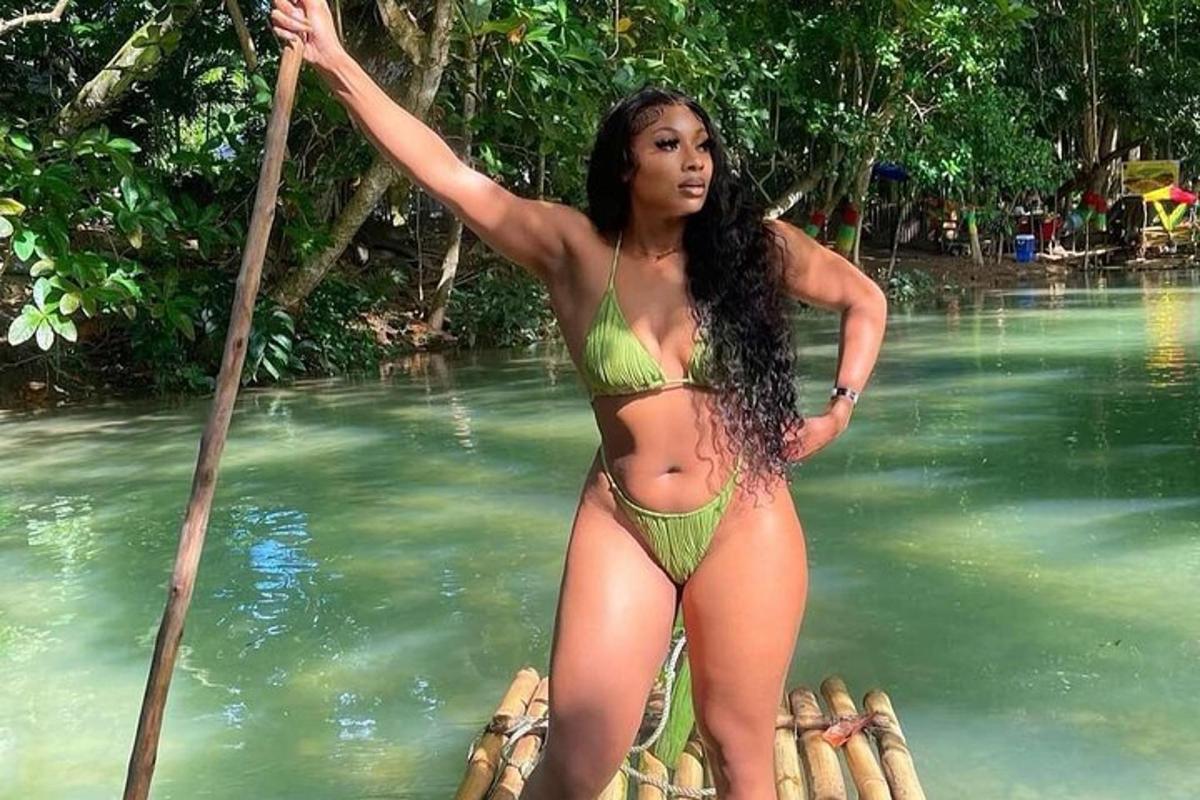 uma mulher de biquíni verde em um barco na água