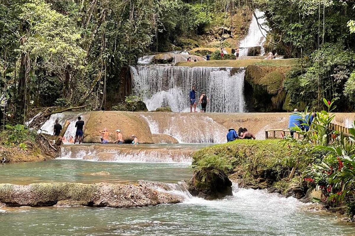sekelompok orang berdiri di depan air terjun