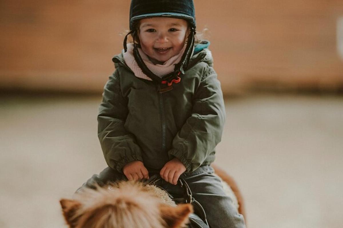 một đứa trẻ đang ngồi trên lưng ngựa