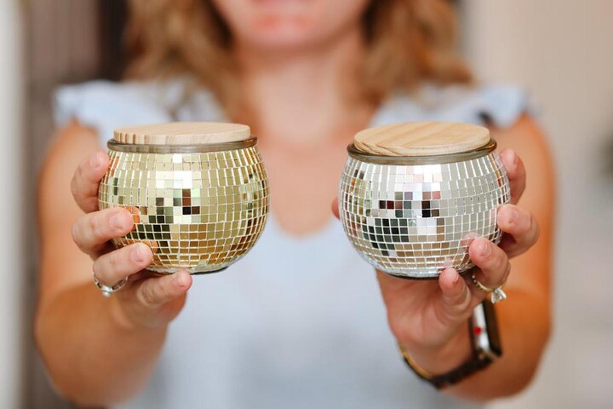 a woman holding two gold drums in her hands