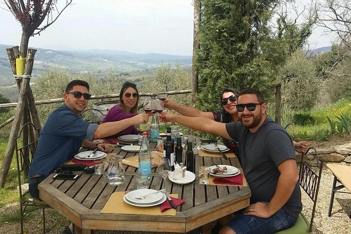 skupina lidí sedících u stolu a pijících víno
