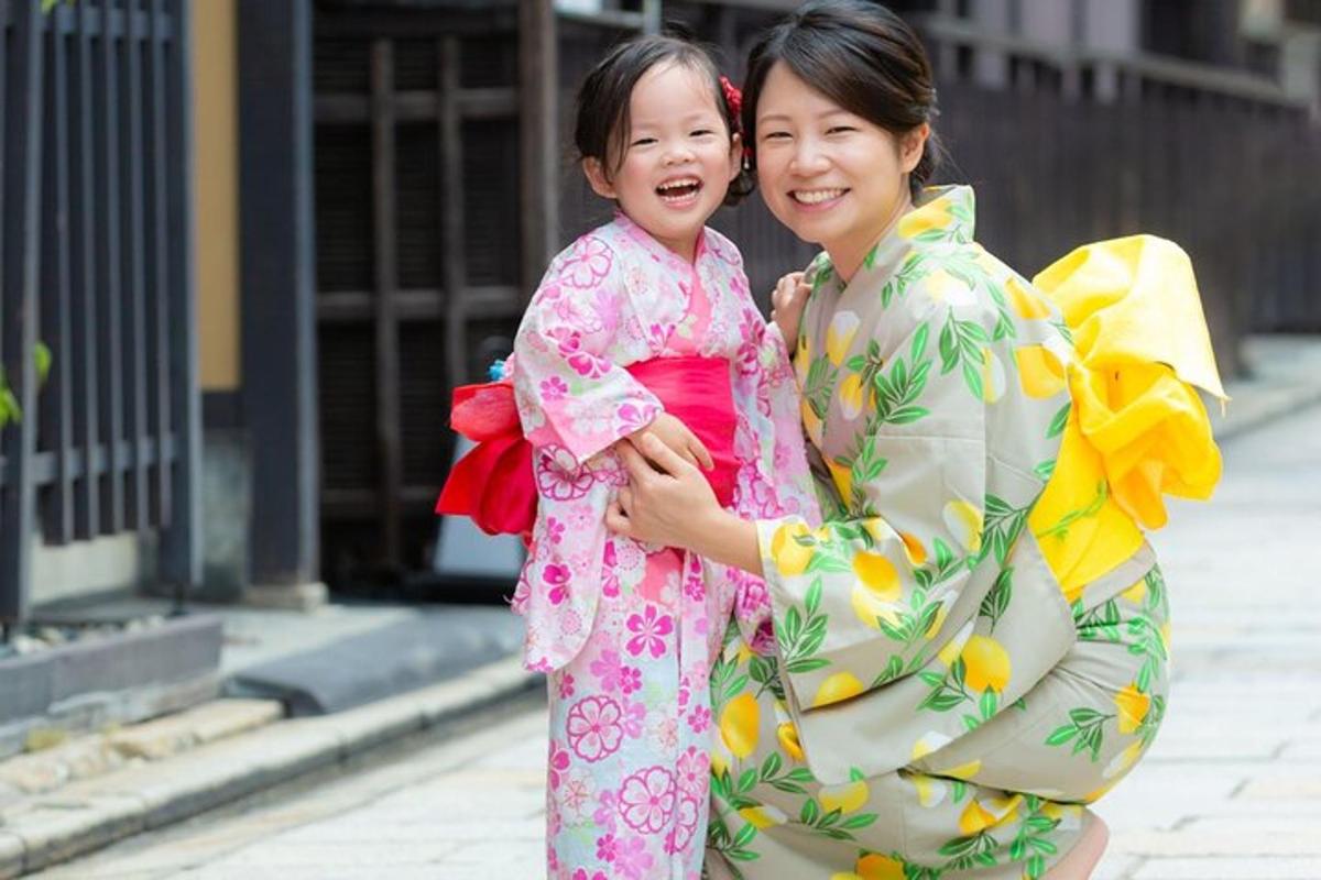 naine, kes hoiab süles väikest kimonos tüdrukut