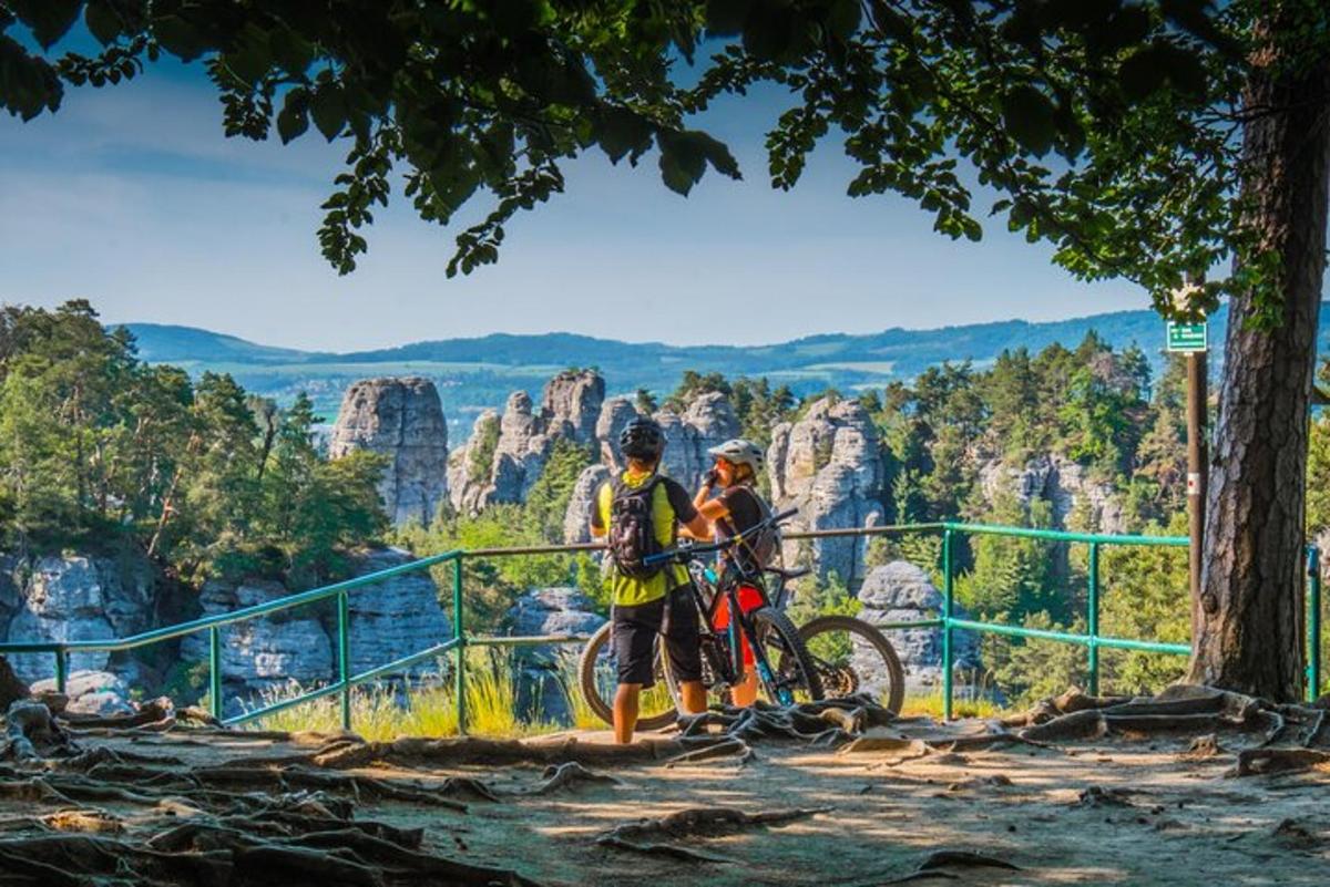 duas pessoas com suas bicicletas nas montanhas azuis