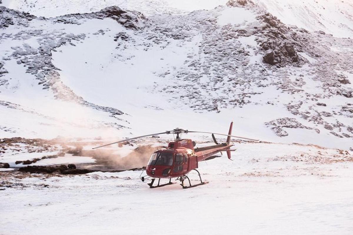 en helikopter parkeret i sneen ved siden af et bjerg