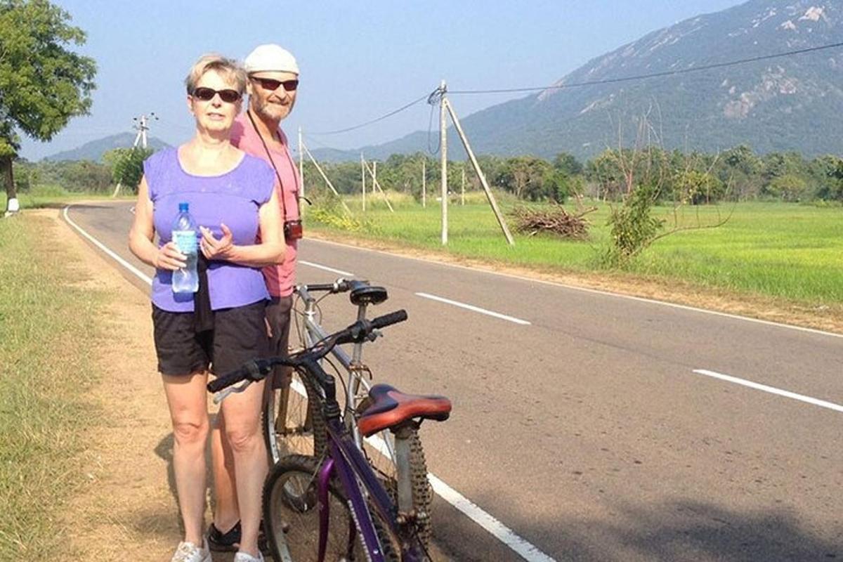 dva lidé stojící vedle kola na silnici