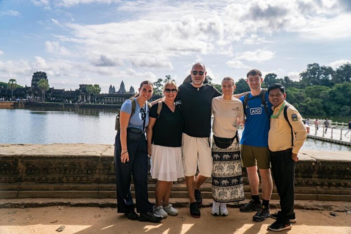 uma família posando para uma foto em frente à água