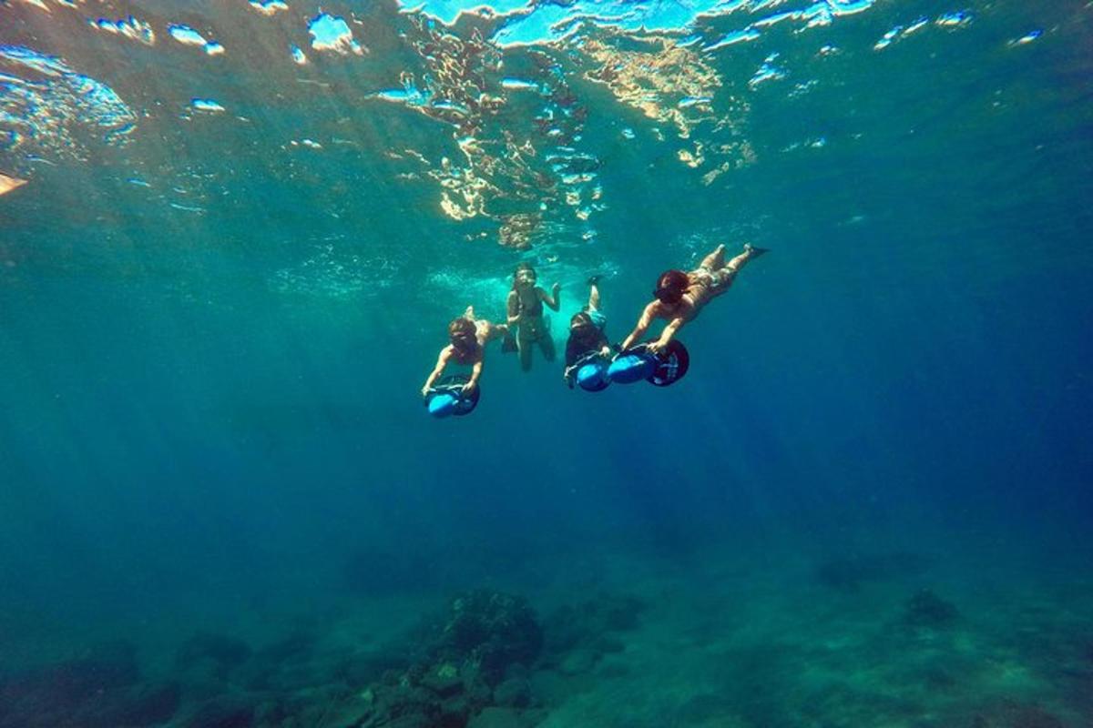 eine Gruppe von Menschen, die auf Rollern im Wasser fahren