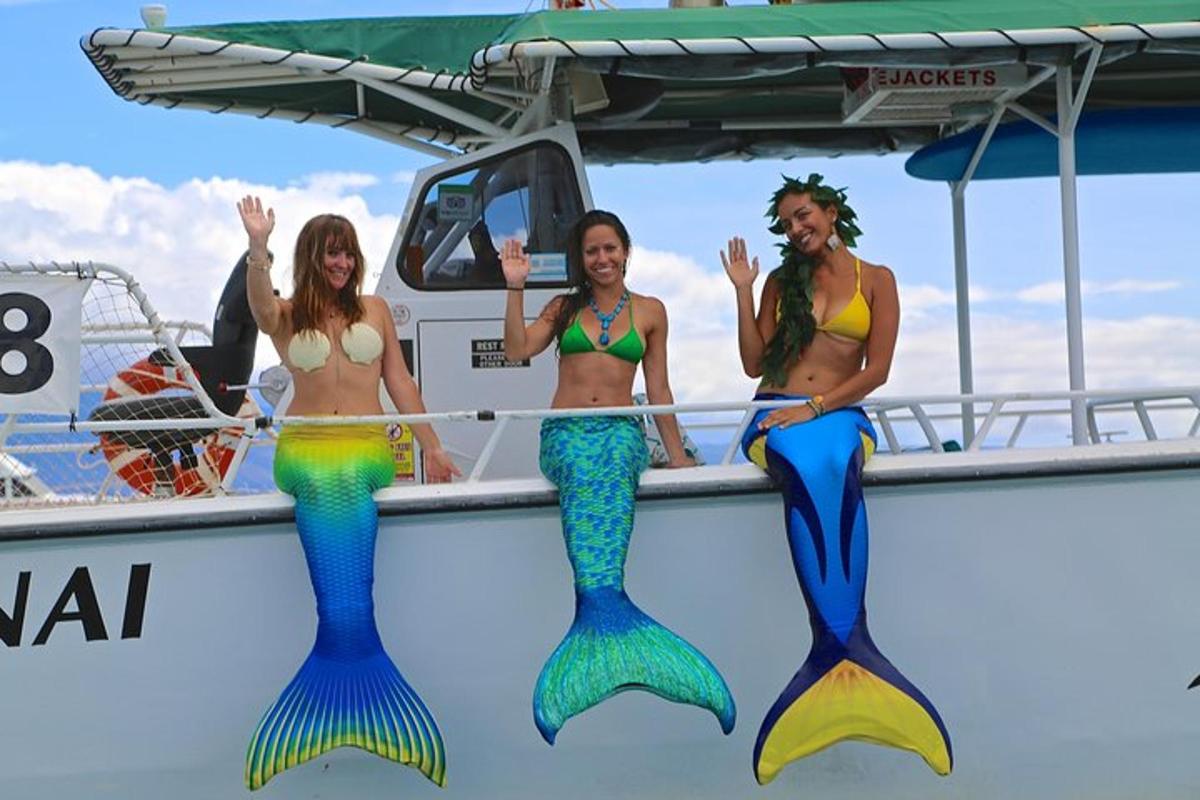 tre donne in costume da bagno in piedi su una barca