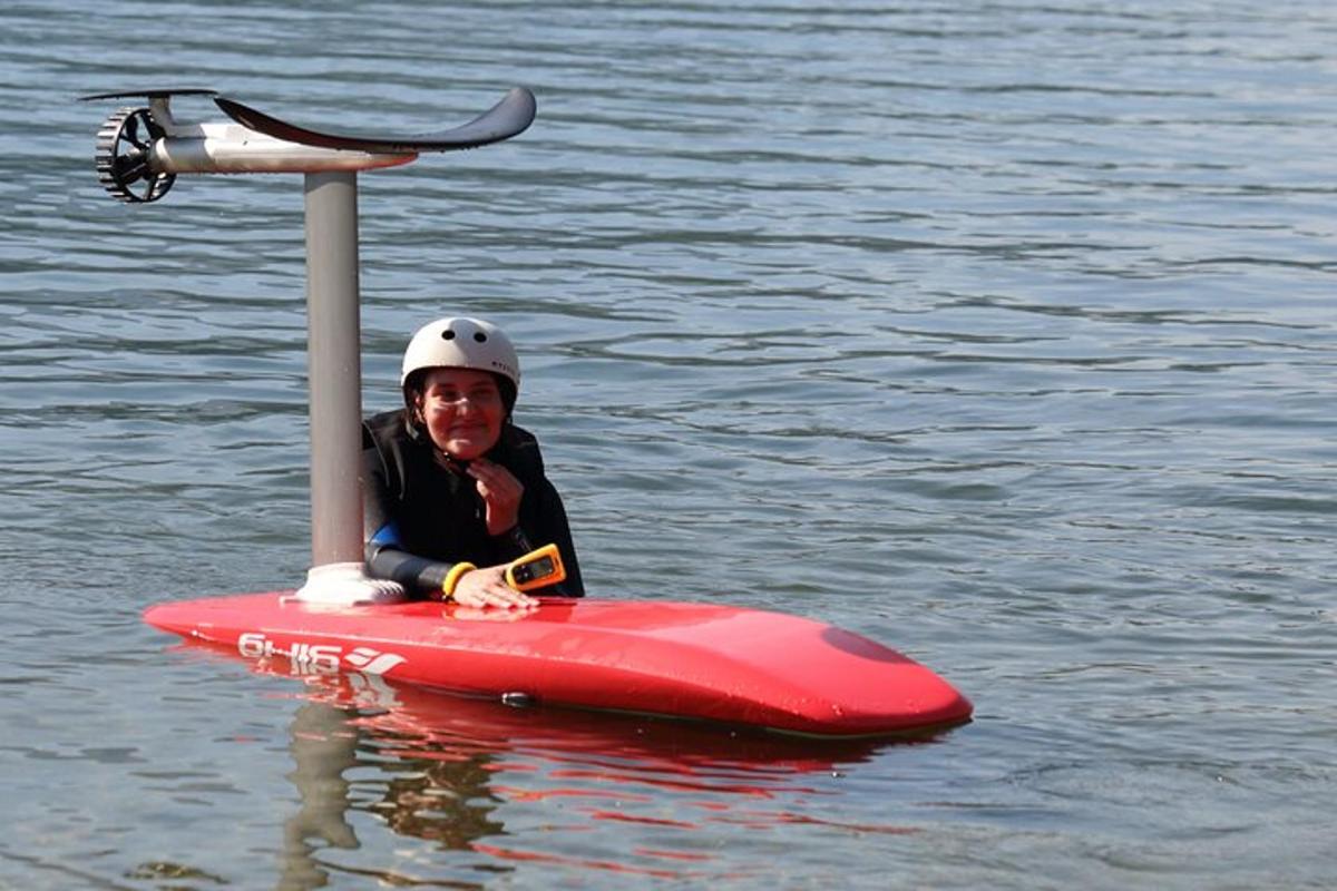 osoba sedící na červeném paddleboardu ve vodě