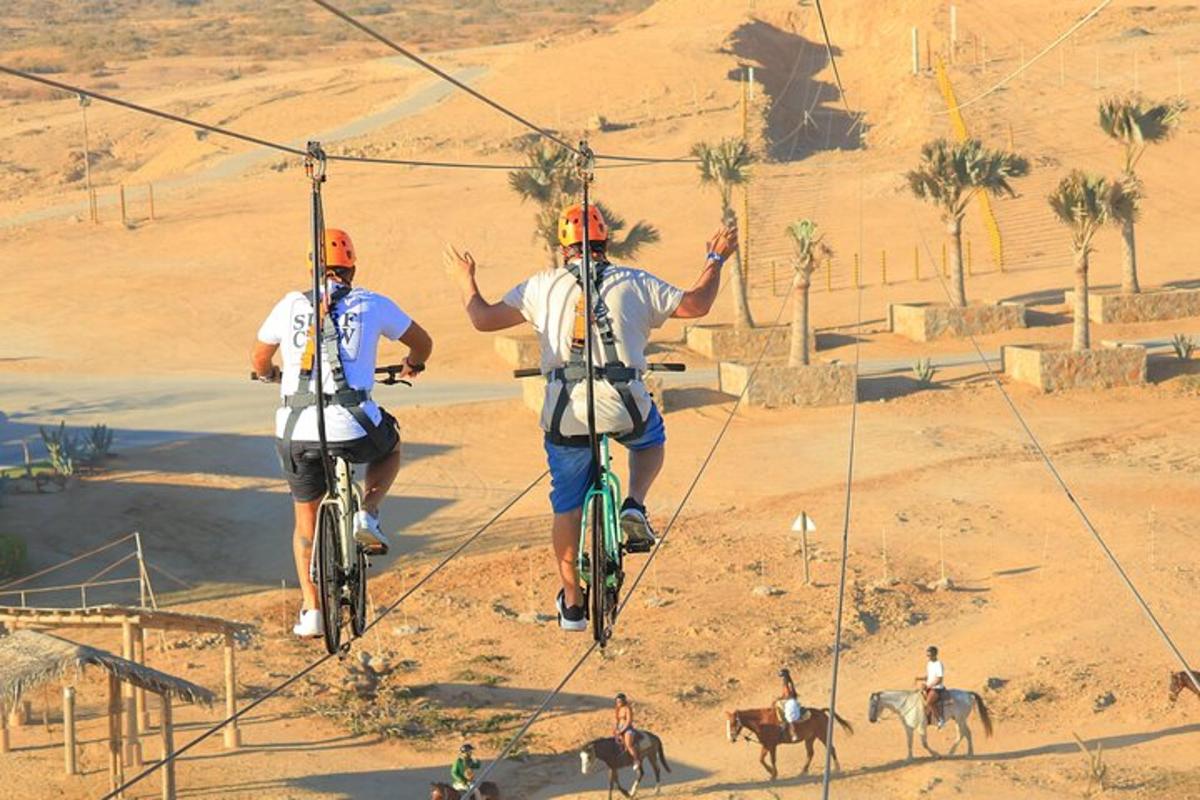 to menn som sykler på en zipline i ørkenen