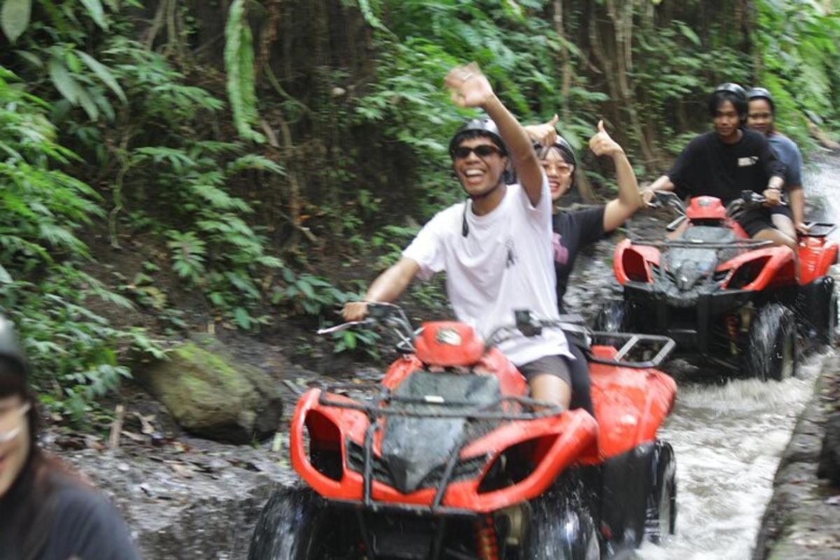 Un grupo de personas viajando en vehículos todo terreno en el bosque.