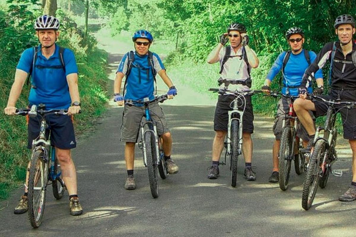 eine Gruppe von Männern, die mit dem Fahrrad eine Straße entlangfahren