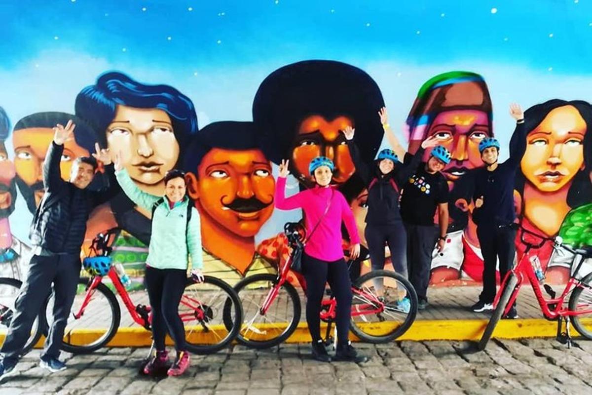 un grup de oameni cu biciclete în fața unei picturi murale