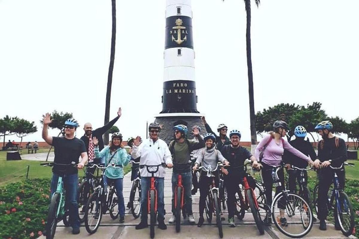un grup de oameni pe biciclete în fața unui far