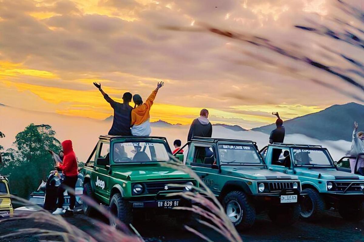 a group of people sitting on top of their cars