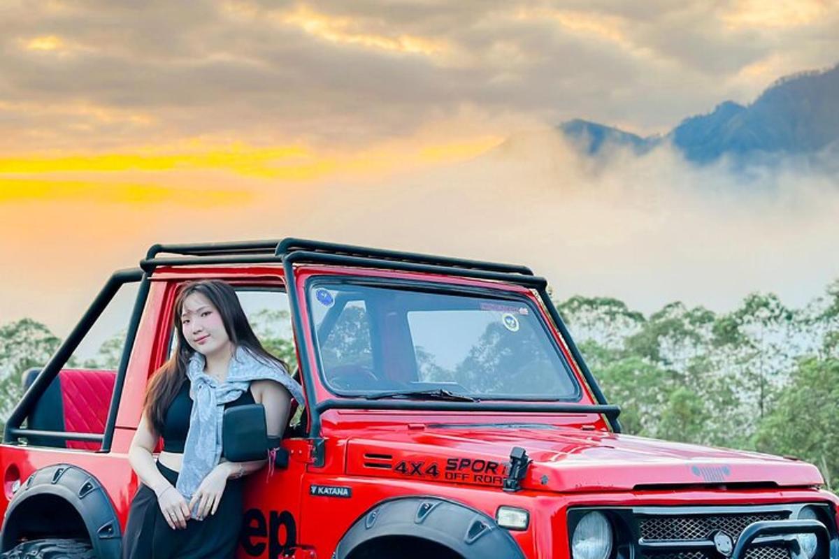 una donna seduta sul retro di una jeep rossa