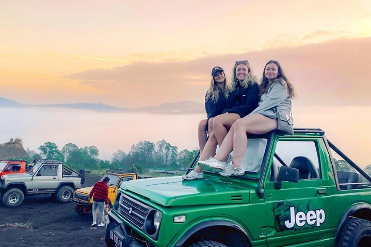 tre ragazze sedute sul tetto di una jeep verde