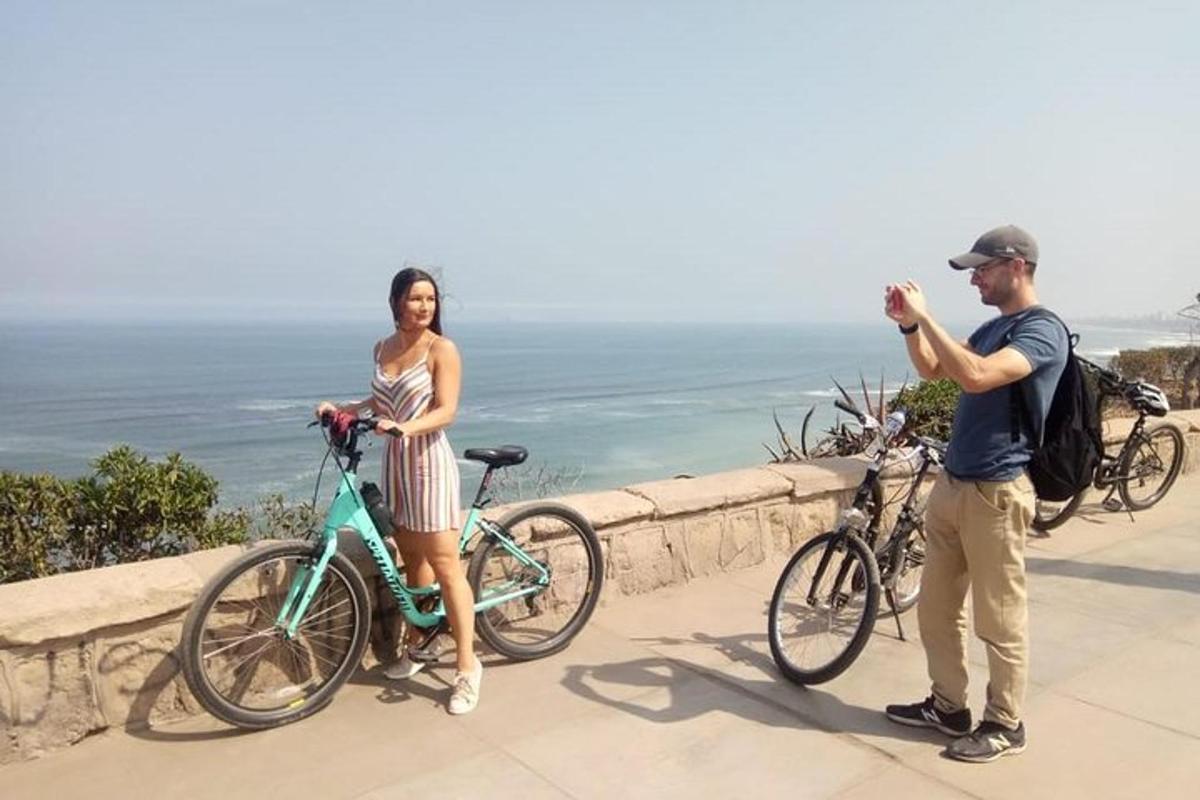 un bărbat care fotografiază o femeie cu o bicicletă