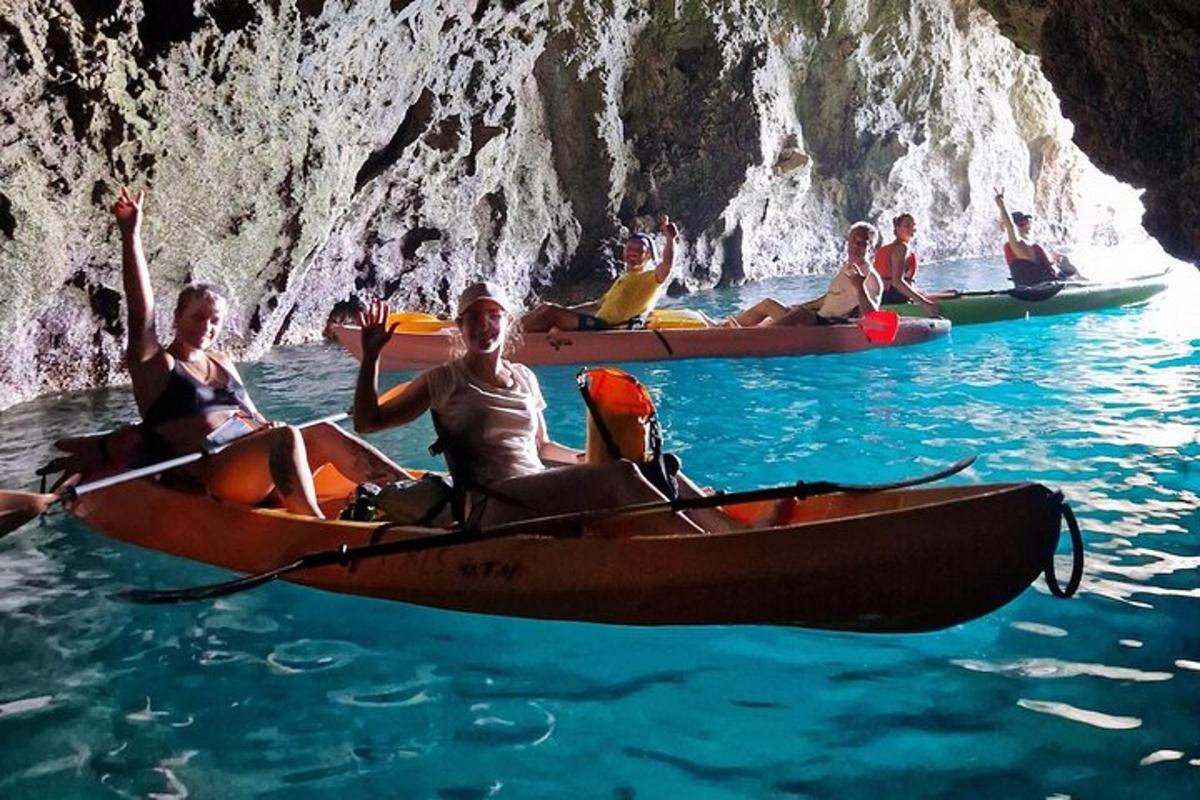 un gruppo di persone che fa kayak in acqua vicino a una grotta
