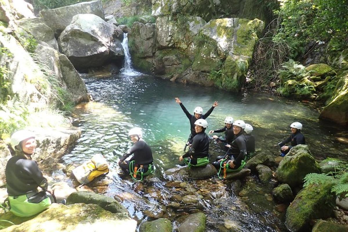 um grupo de pessoas sentadas em um rio com uma cachoeira