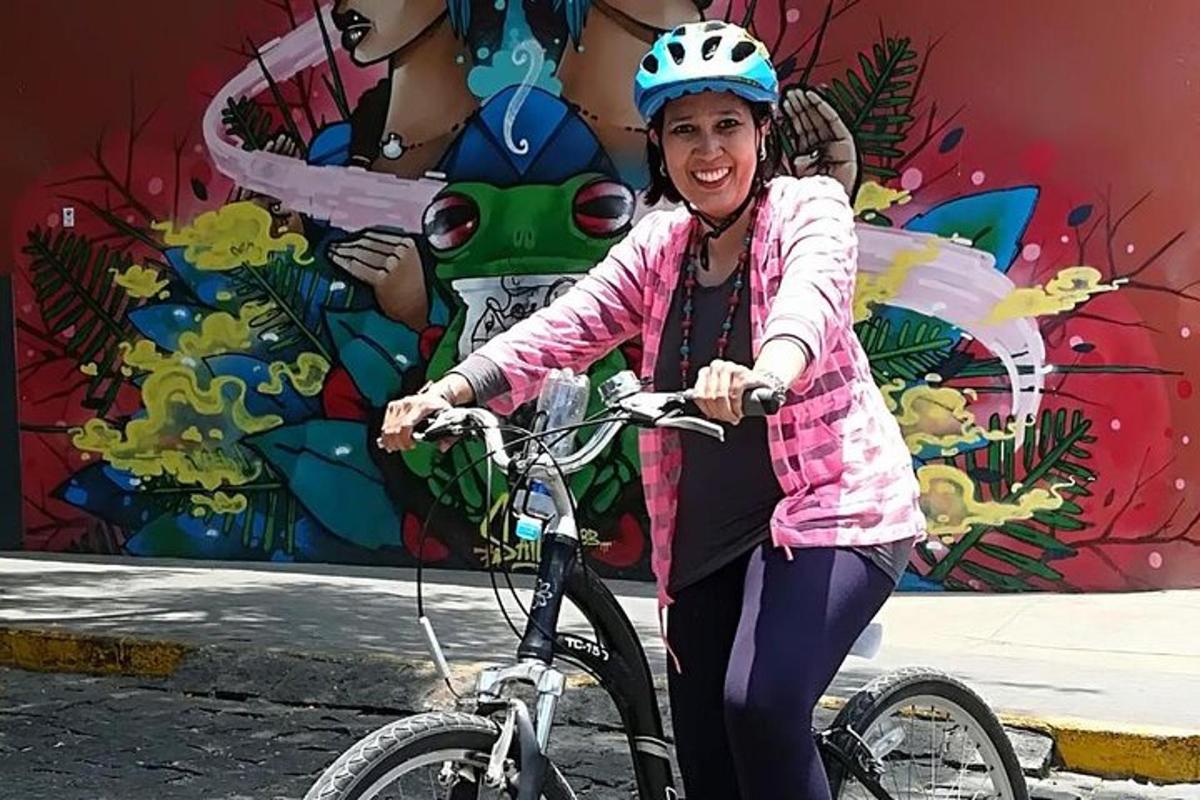 壁画の前で自転車に乗る女性