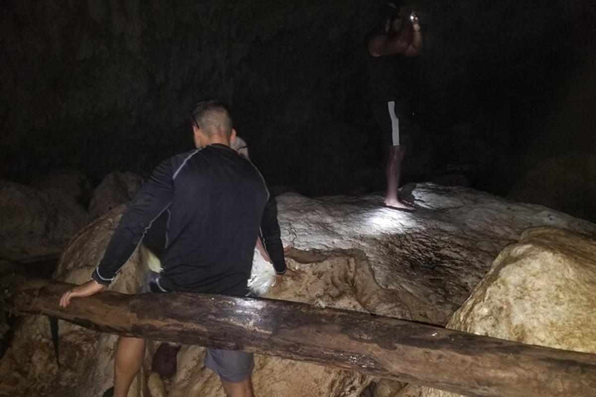 muž stojící na skále a dívající se na muže na holi