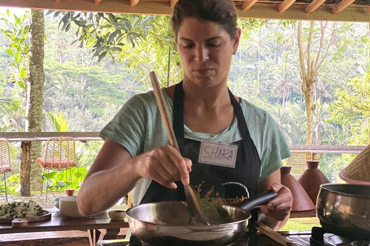 una mujer revolviendo una olla en una estufa con palillos