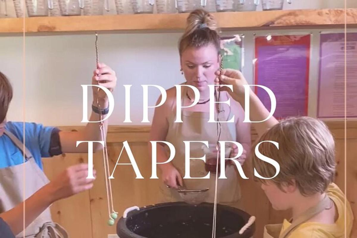 a woman and two children cooking food in a pan