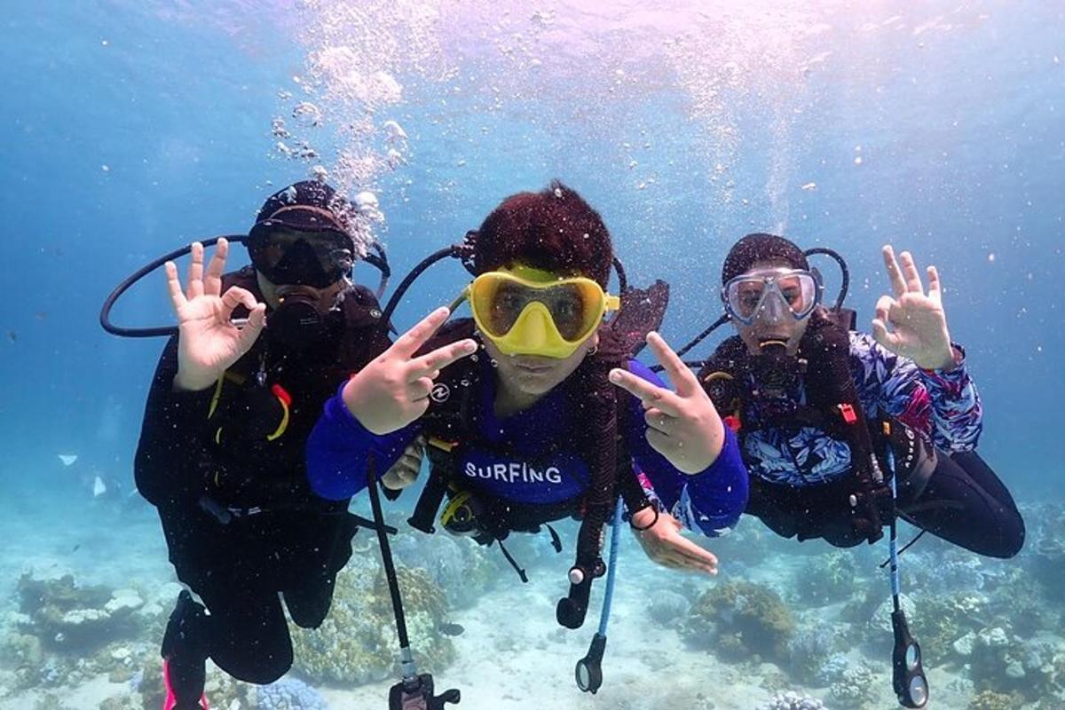 tre persone in acqua con le mani in aria